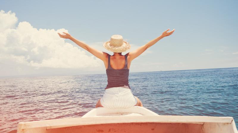 woman on a boat with arms out